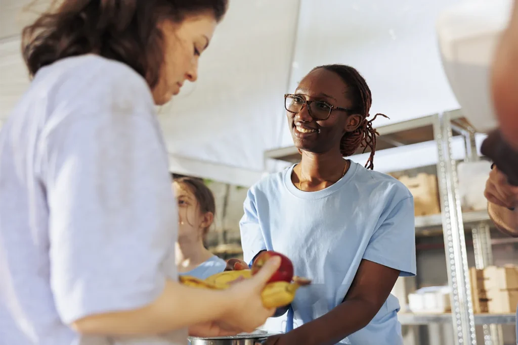 caring volunteer distributing food to single mom
